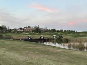 - un groupe de voiturettes de golf sur un pont sur une rivière dans l'établissement Balloons and Wine, à Murrieta