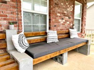 a bench on a porch with pillows on it at Renovated home 10 min from FLW! in Saint Robert