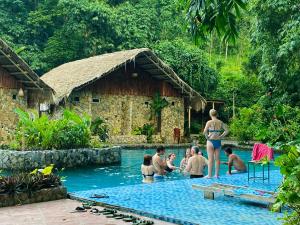 Ải Hạ的住宿－Le Pont Mu Waterfall Homestay，一群人在度假村的游泳池里