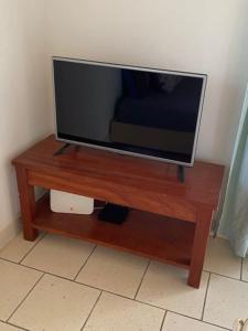 a flat screen tv sitting on top of a wooden table at Beach residence vila with pool in Kabrousse