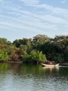 a person in a boat on a body of water at Beach residence vila with pool in Kabrousse