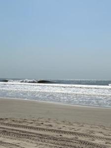 a person standing on a beach near the ocean at Beach residence vila with pool in Kabrousse