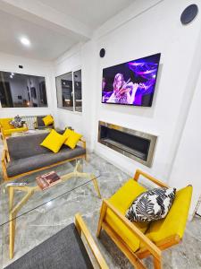 a living room with a couch and a tv on a wall at Las Victorias Suites Bariloche in San Carlos de Bariloche