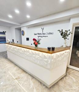 a reception counter in a lobby with flowers at Las Victorias Suites Bariloche in San Carlos de Bariloche