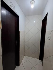 baño con puerta negra y pared blanca en Hotel pousada sonho meu, en Arapiraca
