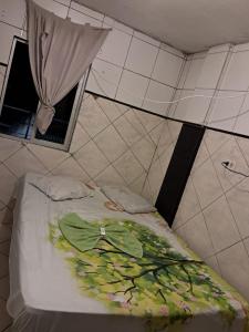 Una cama con hojas en una habitación en Hotel pousada sonho meu, en Arapiraca