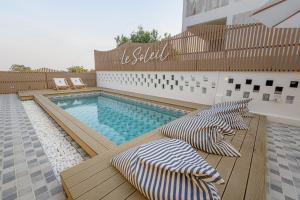 una piscina con 2 tumbonas en una terraza junto a un edificio en Le soleil koh Larn en Ko Larn