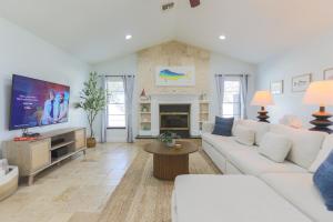 a living room with a white couch and a tv at Snook Haven - Hot Tub, Pool, Minigolf, Dog Space in Largo