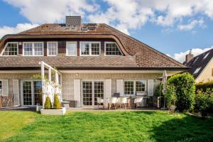 une maison avec une terrasse et une cour dans l'établissement Großzügiges Ferienhaus an der Ostsee, à Scharbeutz