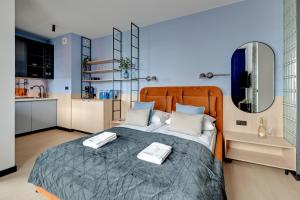 a bedroom with a bed with two towels on it at Doki Studio Superior by Grand Apartments in Gdańsk