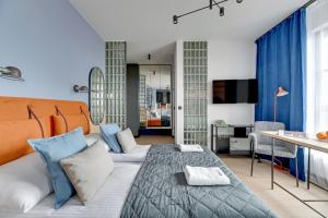 a bedroom with a bed and a living room at Doki Studio Superior by Grand Apartments in Gdańsk