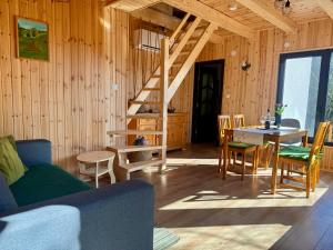 a living room with a staircase and a table and chairs at Aproka - Chalet Mignon Adorable small guest house in Sicasău