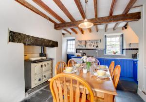 a kitchen with blue cabinets and a wooden table and chairs at Ty Newydd in Dolgellau