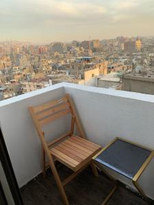 a wooden chair sitting on top of a balcony at Heaven Hostel in Cairo
