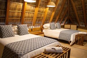 1 dormitorio con 2 camas en una habitación con paredes de madera en Villa Tanatli, en Pérula