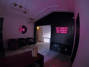 een paarse kamer met stoelen en een bord aan de muur bij Hostal Casa Violeta in Tepic