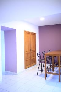 een kamer met een tafel en stoelen en een houten deur bij Hostal Casa Violeta in Tepic