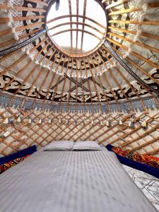 Kaji-Say的住宿－Agat Yurt Camp，蒙古包内的一张大床,设有一个窗口