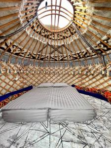 Kaji-SayにあるAgat Yurt Campの大きな窓のあるパオのベッド