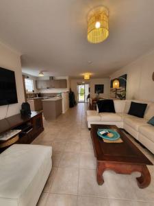 a living room with a couch and a table at Villa Cinta @Cape View Resort in Broadwater