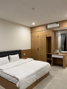 een slaapkamer met een groot bed en een bureau bij Mộc Phương hotel&massage in Kon Tum Kơ Nâm