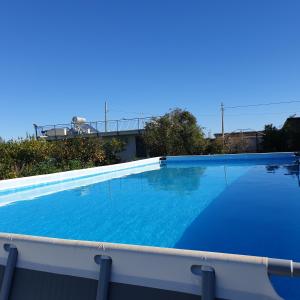 uma grande piscina azul no topo de um edifício em Country house pool and sea em Agnone Bagni
