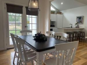 een keuken en eetkamer met een tafel en stoelen bij Evies Belmont Cottage in Geelong