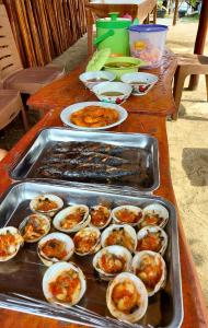 LampungにあるVilla Mangrove Pulau Pahawangの牡蠣などの食べ物を入れたテーブル