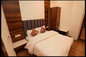 sypialnia z białym łóżkiem i drewnianą ścianą w obiekcie Hotel Aaria w mieście Mussoorie