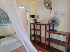 a bedroom with a bed with a fan and a window at AABANA Beach & Watersport Resort in Malapascua Island