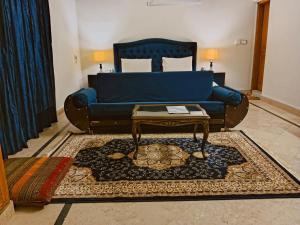 a living room with a blue couch and a coffee table at Infinity Villa in Islamabad