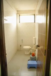 a bathroom with a toilet and a window at Hotel Sachidanand in Shirdi