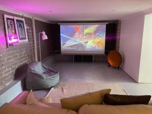 a living room with a couch and a projection screen at Evies White House Oasis I Pool & Close to Airport in Melbourne