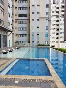 a swimming pool in front of two tall buildings at Cozy1233 studio at The Persimmon in Cebu City