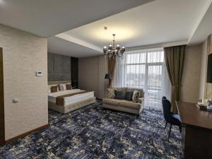 Habitación de hotel con cama y sofá en MirOtel en Shymkent