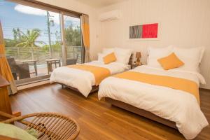 Ένα ή περισσότερα κρεβάτια σε δωμάτιο στο ハワイアンな空間が心身ともに癒してくれる　恩納村真栄田~K’s Casa~