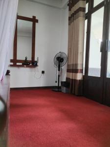 Zimmer mit einem roten Teppich und einem Ventilator in der Unterkunft Ella Shali's home in Ella