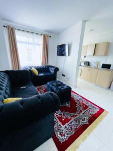 a living room with a black couch and a red rug at Classy two bedroom Airbnb with swimming pool in Kiambu