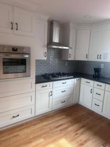 a kitchen with white cabinets and stainless steel appliances at EdisonHollywood in Edison