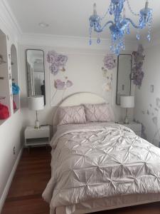 a bedroom with a bed and two mirrors and a chandelier at EdisonHollywood in Edison