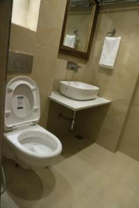 a bathroom with a toilet and a sink at Hotel Aaria in Mussoorie