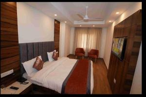 a hotel room with a bed and a television at Hotel Aaria in Mussoorie