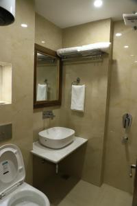 La salle de bains est pourvue d'un lavabo, de toilettes et d'un miroir. dans l'établissement Hotel Aaria, à Mussoorie