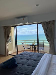 a bedroom with a bed and a view of the ocean at Vip condo chain by Linda in Ban Phe