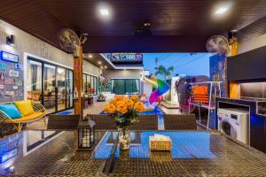 a living room with a table with flowers on it at Sabaidee Pool Villa Cha-am in Cha Am
