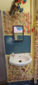 een badkamer met een wastafel met een spiegel aan de muur bij Sri Viswanatham guest House in Varanasi