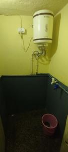 een badkamer met een toilet en een emmer bij Sri Viswanatham guest House in Varanasi