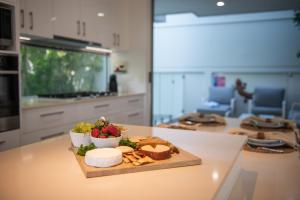 エアリービーチにあるBellevue Holiday Home - Airlie Beachのチーズと果物を入れたカウンターの皿