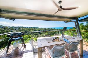 エアリービーチにあるBellevue Holiday Home - Airlie Beachの海の景色を望むデッキ(テーブル、椅子付)
