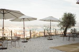 een groep tafels en stoelen met parasols op een strand bij Agriturismo Belvedere 9 in La Spezia